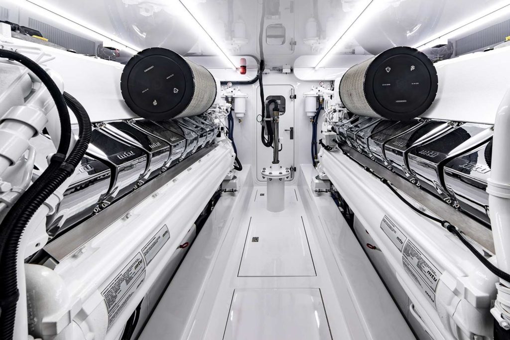 The bright white, black, and chrome interior engine room of a Jarrett Bay Boatworks sport fishing boat.