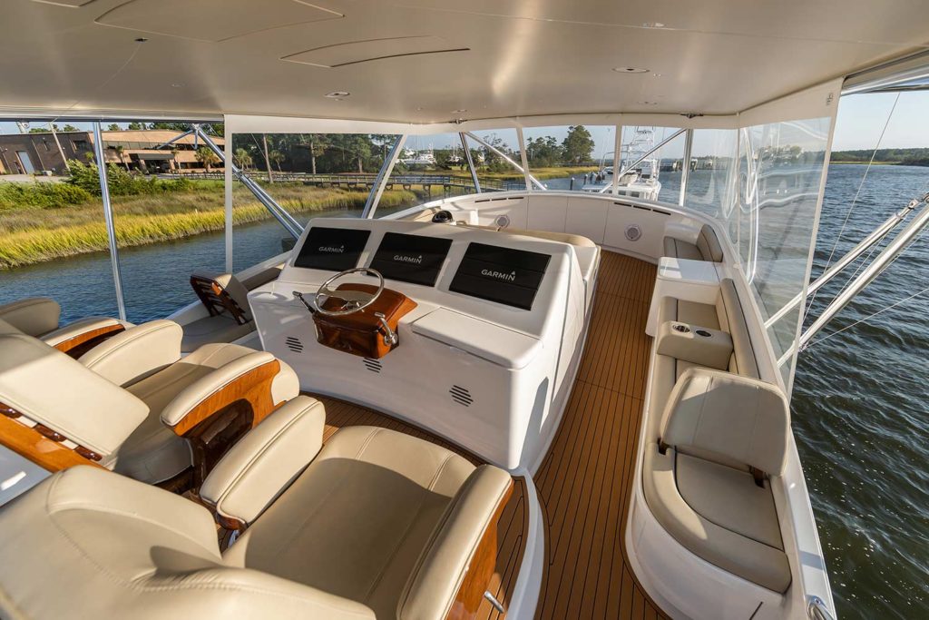 View of a custom sport fishing boat's center console layout showing seats, helm and sun lounge.