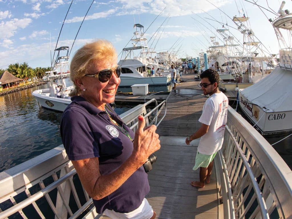 A woman wearing sunglasses walking on a pier.