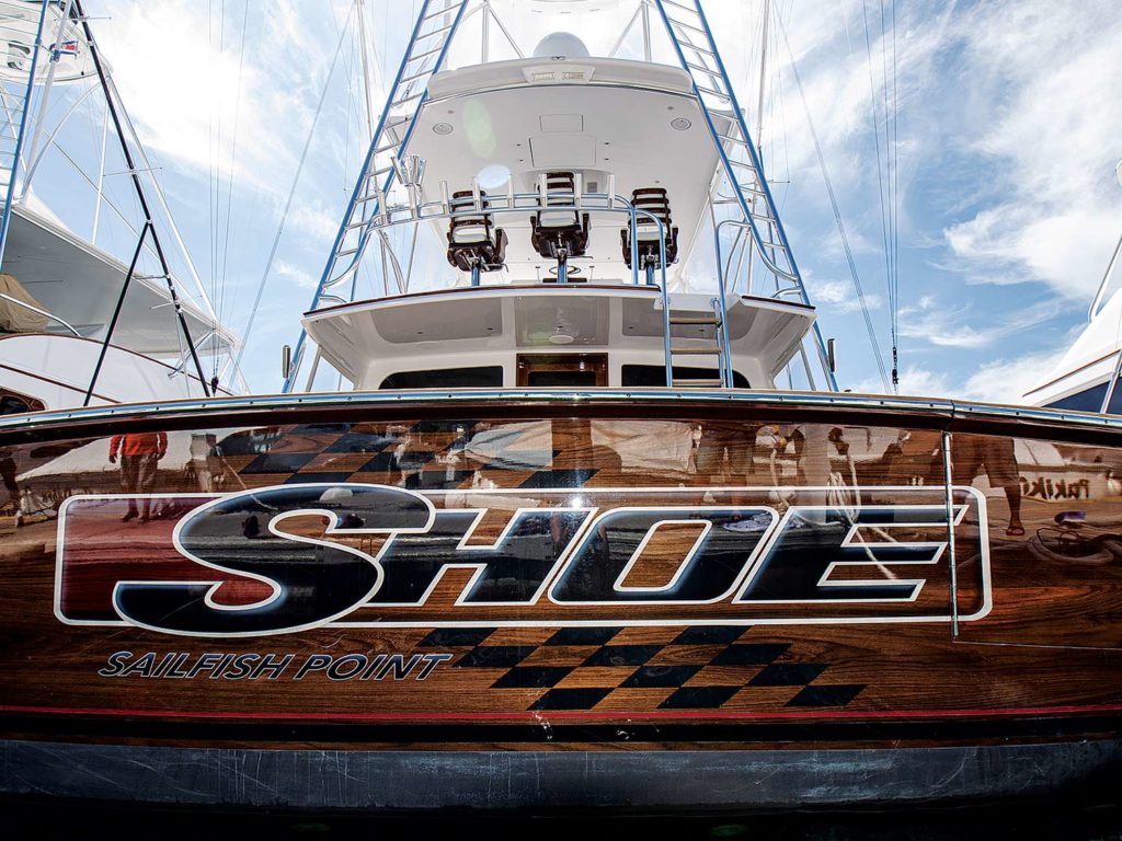 A boat transom with the words "Shoe" painted on the back.