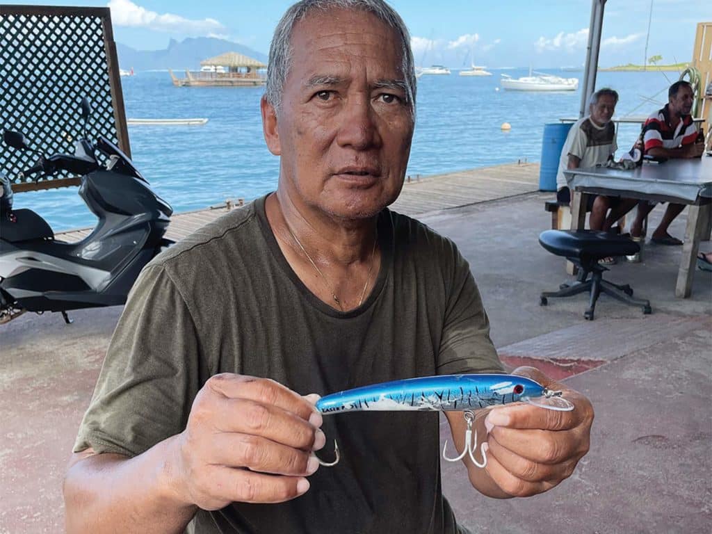 A sport fisher holds up a fishing lure used to catch marlin.