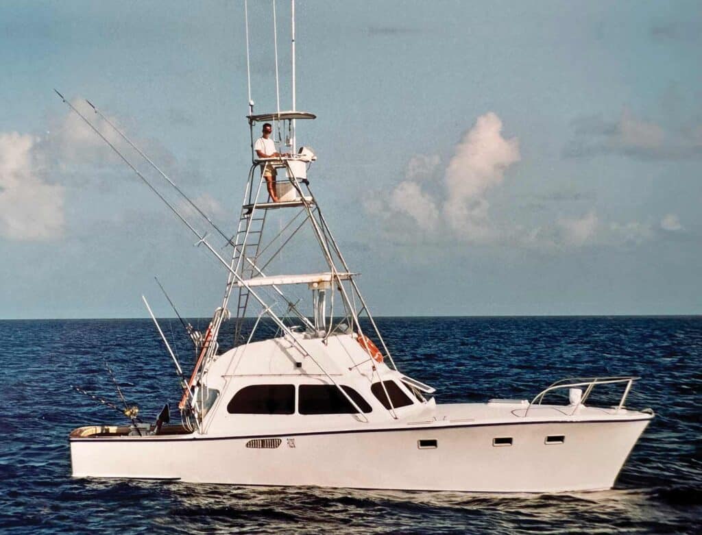 An older photograph of a small sport-fishing boat on the ocean.