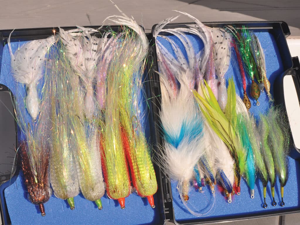 A series of fly lures arranged in a box.