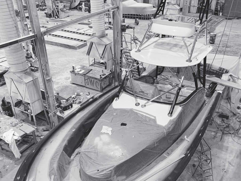 A black and white image of a sport-fishing boat under construction.