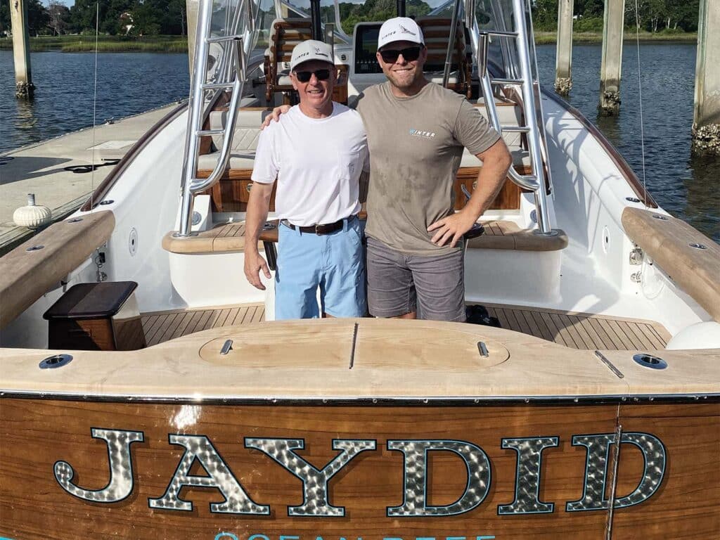 Two men standing in the cockpit of a sport-fishing boat.