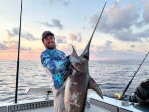 Jerry Menard holds up a large swordfish.