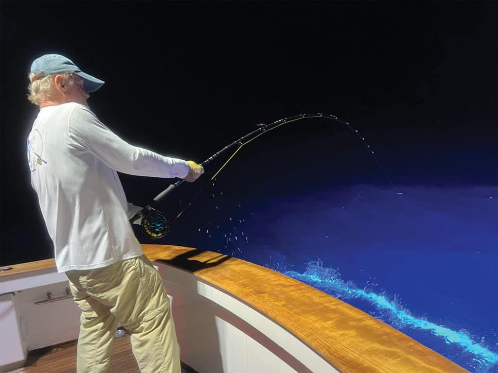 Roy Cronacher fighting a swordfish to reel it in boatside.