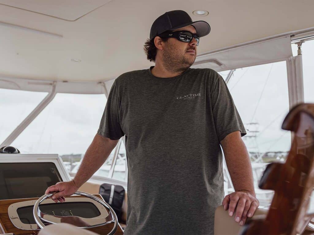 Capt. Phillip Fender stands at the helm of a sport-fishing boat.