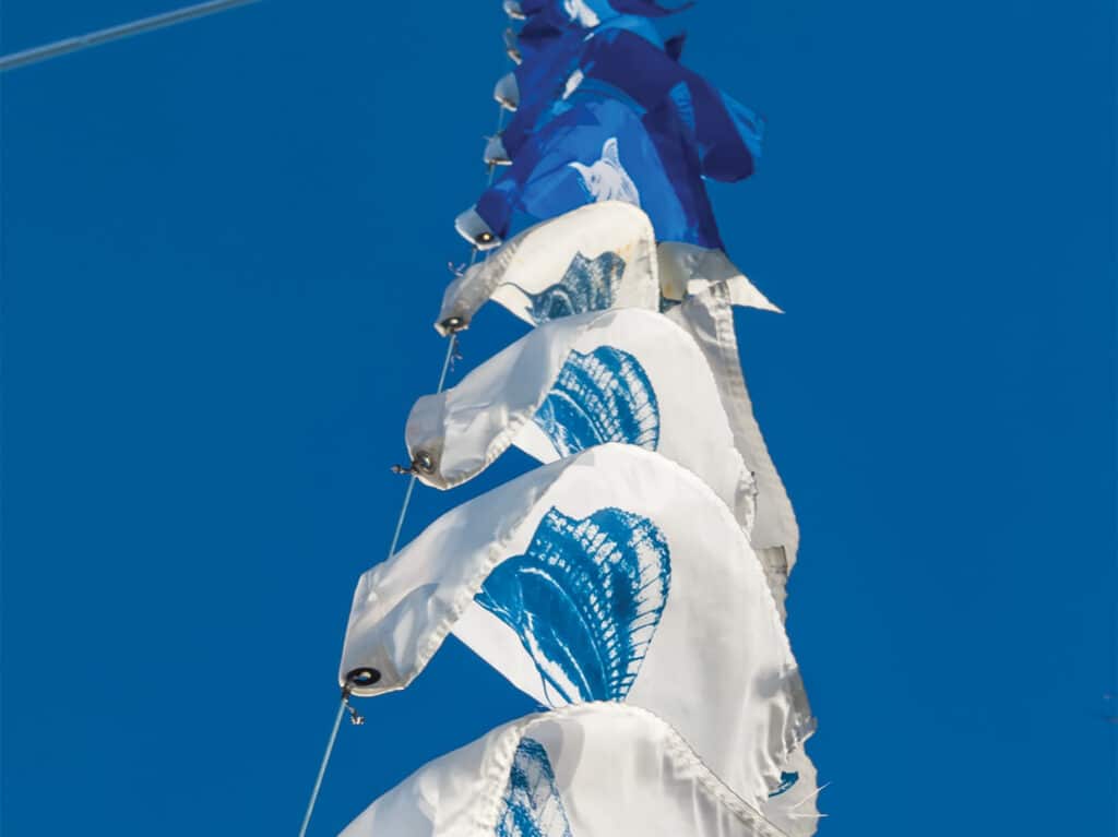 Several marlin and sailfish releases flags flying from the rigging of a sport-fishing boat.