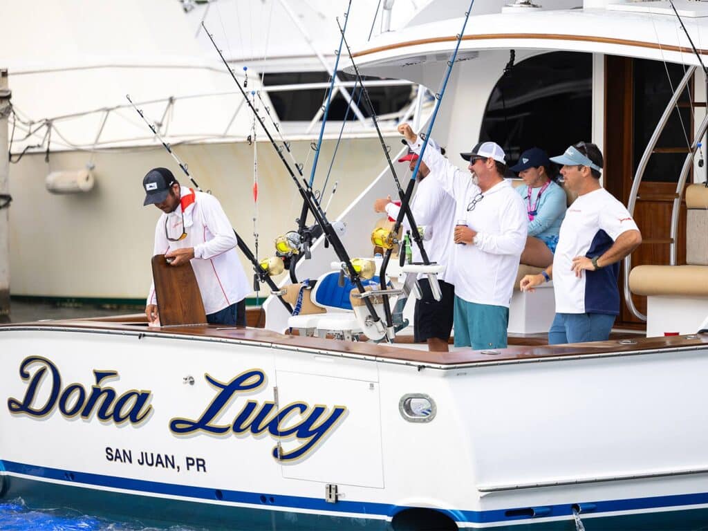 A sport-fishing boat with the crew standing in the cockpit.