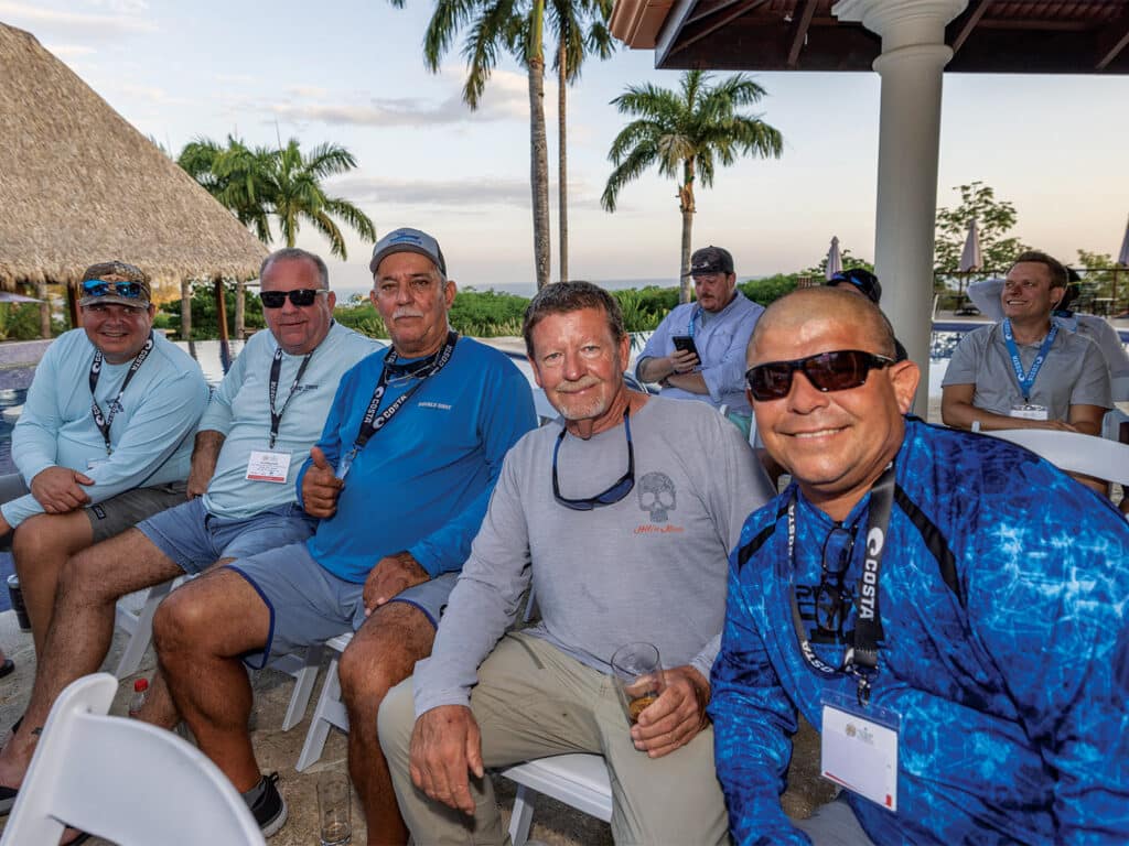 Five men are seated and smiling for the camera.