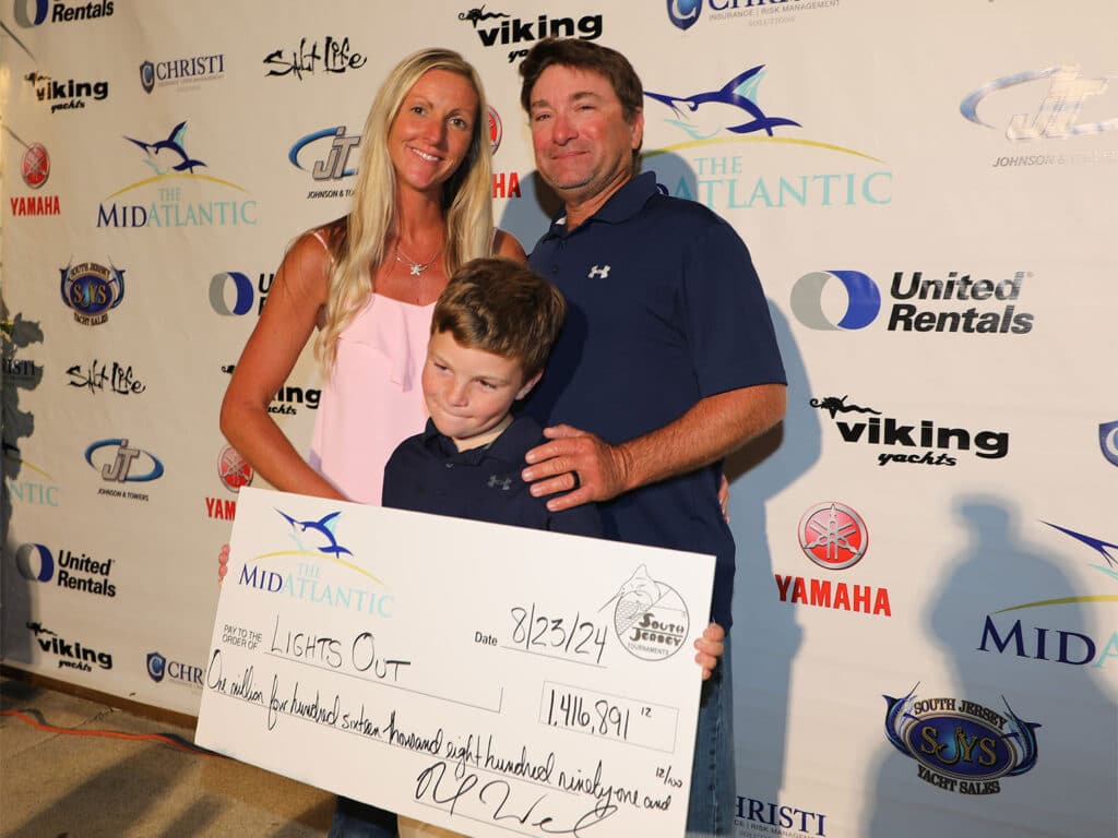 Team Lights Out standing at the awards ceremony. They are holding an oversized check.