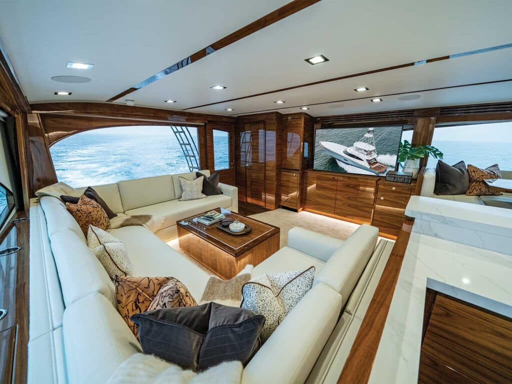 Interior salon of the Viking 82 sport-fishing boat showing lush cushions and seating and wood work finishes.