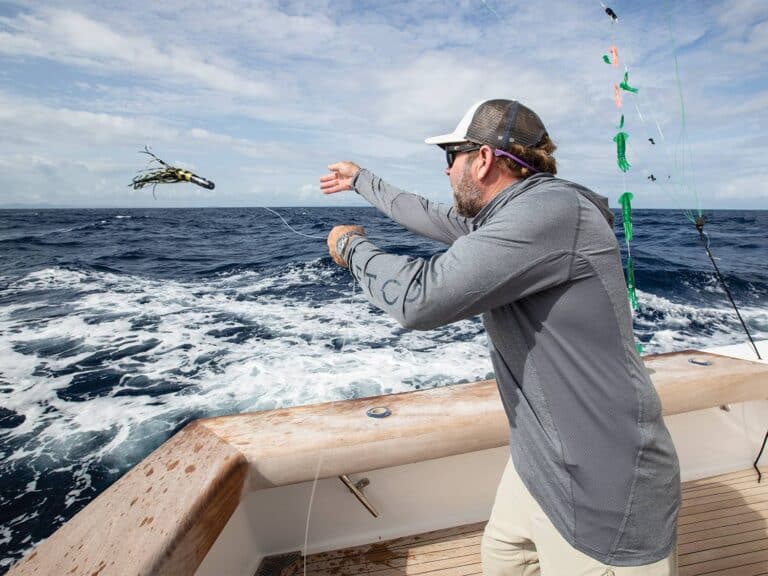 A sport-fishing angler pitches a skirt lure.