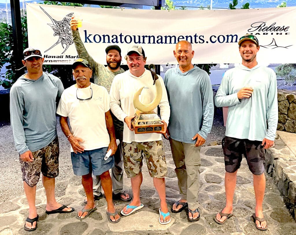 A team of sport-fishing anglers standing at an awards ceremony.