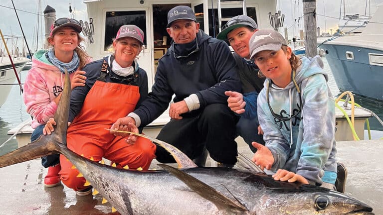 A family next to a bluefin tuna.