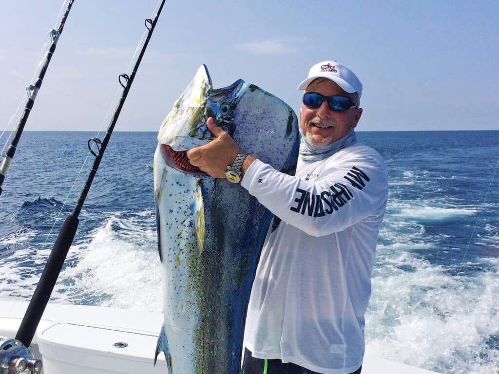 Russ Garufi poses for the camera while holding a large dorado.