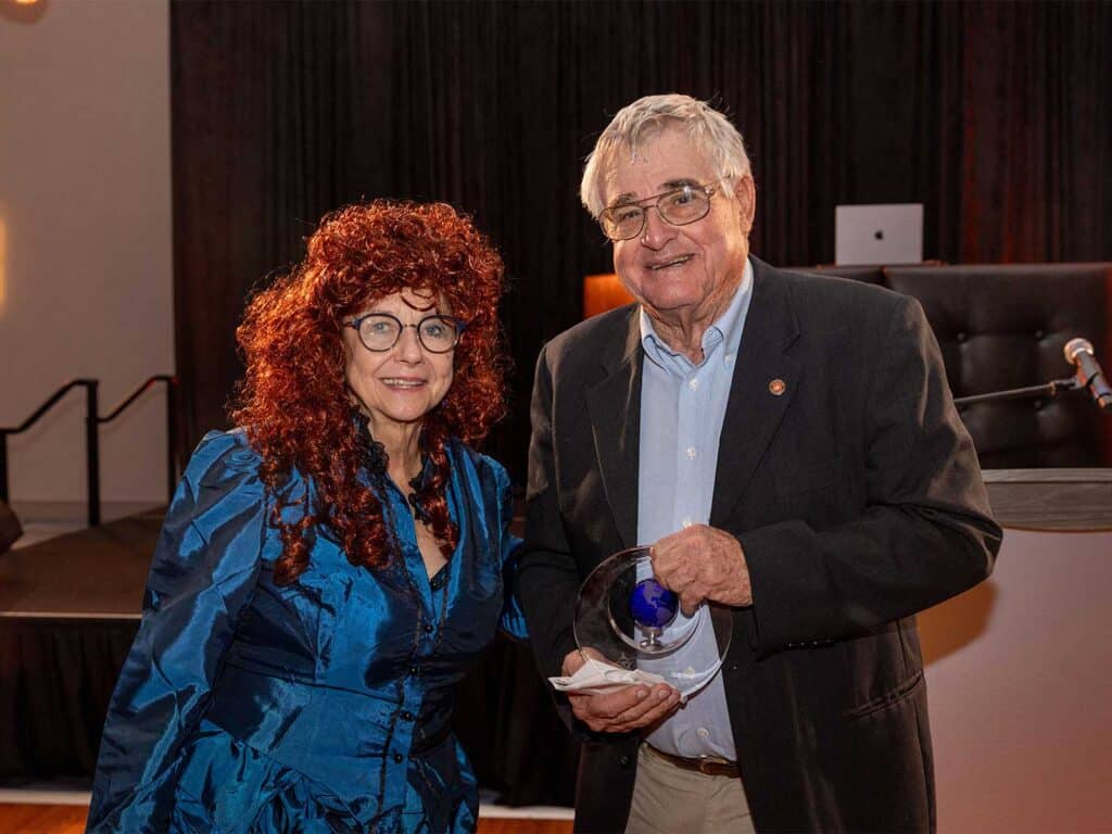 Ellen Peel poses with Capt. Chip Shafer. He holds up his award.