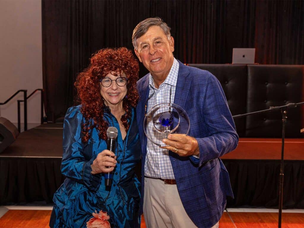 Ellen Peel poses with Sam Peters. He holds up his award.