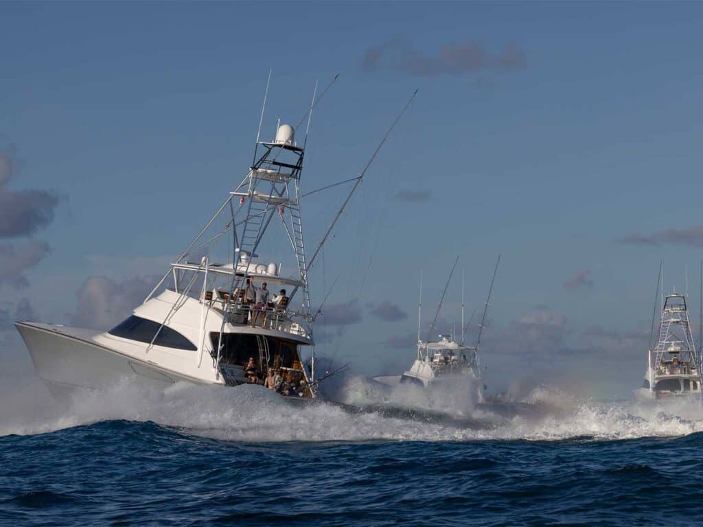 Three sport-fishing boats cruising across the ocean.