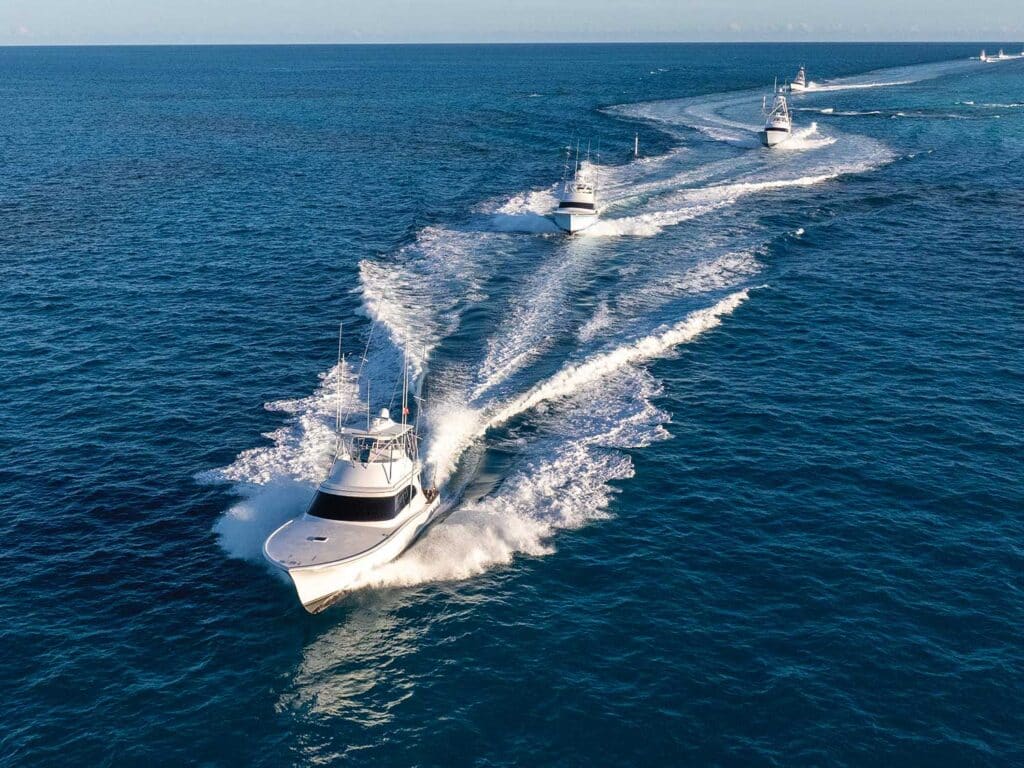 A fleet of sport-fishing boats cruising on the ocean.