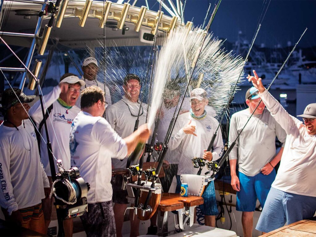 A sport-fishing team celebrates by spraying champagne everywhere.