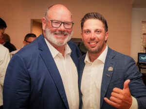 Two men smile and pose for the camera.